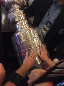 Author's hand touching the Stanley Cup